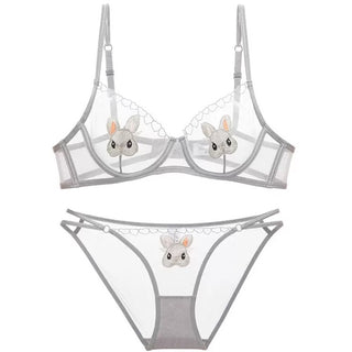 Grey lacy bra and pantie set with bunnies rabbit design set against a plain white background